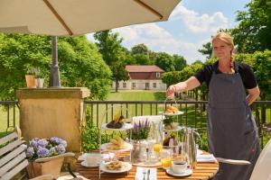 a woman in an apron preparing food on a table at Schloss und Gut Liebenberg in Liebenberg