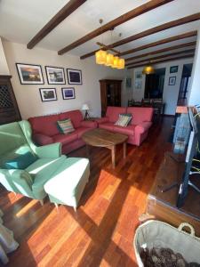 sala de estar con sofás rosados y mesa en Bajo con terraza y vistas a las montaña en Formigal en Formigal