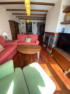 sala de estar con sofá, mesa y TV en Bajo con terraza y vistas a las montaña en Formigal, en Formigal