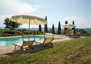 a group of chairs and umbrellas next to a pool at Terre Di San Gorgone in Donnini