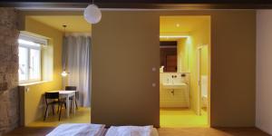 Cet appartement comprend une chambre avec un lit et une table ainsi qu'une cuisine. dans l'établissement Baumann & Müller, à Walsheim