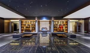 a lobby of a hotel with couches and wine bottles at 洛阳Travel World Hotel in Luoyang +20 photos