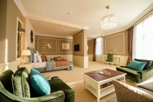 sala de estar con cama, sofá y sillas en Royal Casino & Hotel, en Batumi