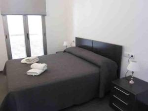 1 dormitorio con 1 cama con 2 toallas en Voramar 33A - Joana Attic, en Puerto Pollensa