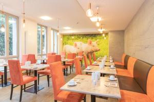 a restaurant with tables and chairs and a mural of cows at Radlhotel Wassertrüdingen in Wassertrüdingen +12 photos
