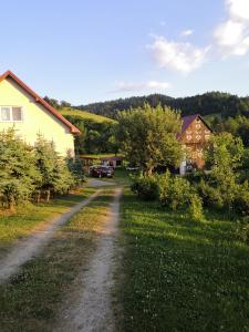 un camino de tierra en un patio con casas y árboles en Ubytovanie u Božky en Dlhá nad Oravou