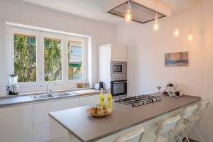 een keuken met witte kasten en een fornuis met oven bij WHITE HOUSE SORRENTO - CASA VACANZA in Sorrento