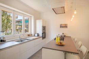 een witte keuken met een wastafel en een aanrecht bij WHITE HOUSE SORRENTO - CASA VACANZA in Sorrento