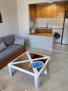 a living room with a coffee table and a kitchen at Helen's studio 1 in Myrina +2 photos