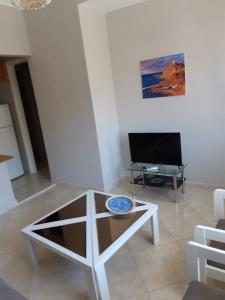 a living room with a coffee table and a flat screen tv at Helen's studio 1 in Myrina
