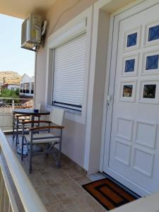 balcón con puerta, mesa y sillas en Helen's studio, en Mirina