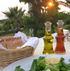 a table with two bottles of wine and a plate of food at Hotel Plakures in Falasarna