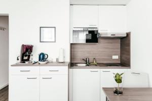 a kitchen with a white counter top and white cabinets at Haus am Dom - Apartments und Ferienwohnungen in Cologne