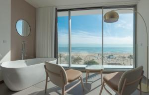 a bathroom with a tub and a view of the ocean at RH Bayren Hotel & Spa 4* Sup in Gandía