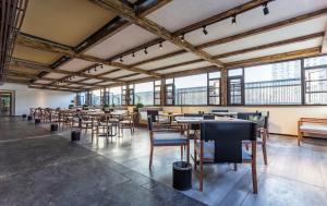 a row of tables and chairs in a room with windows at 洛阳Travel World Hotel in Luoyang