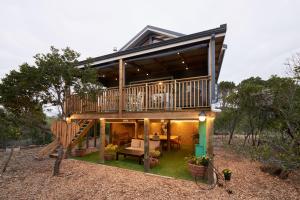 a house with a large deck and a patio at Treedom Villas and Vardos in Wilderness