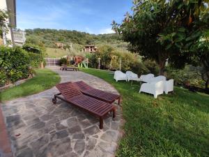 a group of chairs and a wooden bench in a yard at That's Amore Cilento Country House in Agnone