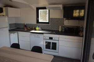een kleine keuken met witte apparatuur en een raam bij bateau du moulin girault in Panzoult