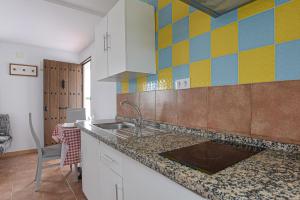 コニル・デ・ラ・フロンテーラにあるApartamento Villa Mayo Cのカラフルなタイルの壁、シンク付きのキッチンが備わります。