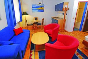 salon z czerwonymi i niebieskimi krzesłami oraz stołem w obiekcie Wald-Hotel w mieście Troisdorf