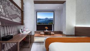 a bedroom with a bed and a window with a view at 洛阳Travel World Hotel in Luoyang