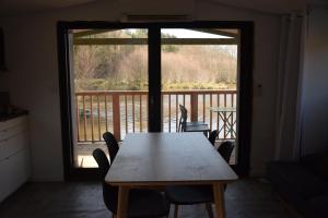 a table and chairs in a room with a balcony at bateau du moulin girault in Panzoult