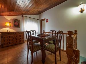 a dining room with a wooden table and chairs at Finca Engracia in Cudillero