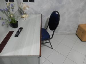 a chair sitting next to a desk with a remote control at Albergo Posta in Genoa