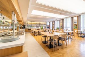 restauracja z drewnianymi stołami, krzesłami i oknami w obiekcie SeaPark Hotel Wellness & Spa w Kołobrzegu