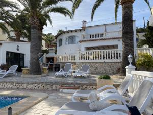 pies siedzący na fotelu przed domem w obiekcie Villa Emilia 8 PAX w mieście Calpe