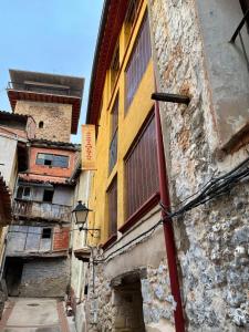 eine Gasse in einer Altstadt mit einem gelben Gebäude in der Unterkunft El Rinconcito in Fuentespalda