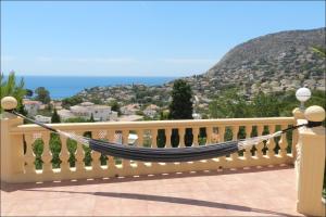 a hammock on a balcony with a view of the ocean at Casa Sueño in Calpe