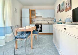 a kitchen with a table and chairs and a kitchen with white cabinets at Stella Marina in Santa Maria Navarrese