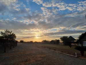 a sunset over a field with the sun setting at Sundowners Game Lodge in Marble Hall
