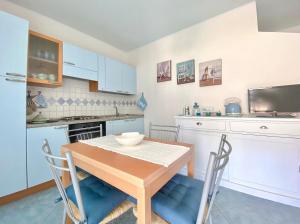 a kitchen with a wooden table and blue chairs at Stella Marina in Santa Maria Navarrese +12 photos