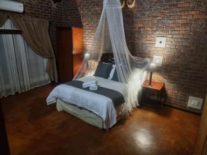 a bedroom with a bed with a mosquito net at Sundowners Game Lodge in Marble Hall