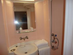 a bathroom with a sink and a mirror at Lac'Hotel France in Montréal La Cluse