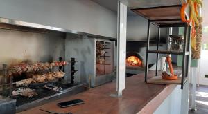 a large oven with meat and a fire in it at Naiades Almiros River Hotel in Agios Nikolaos