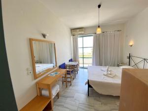 a hotel room with a bed and a table and chairs at Hotel Plakures in Falasarna