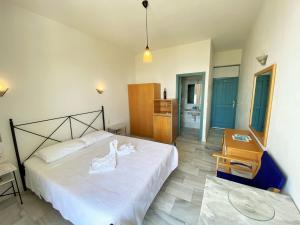 a bedroom with a bed and a chair and a table at Hotel Plakures in Falasarna
