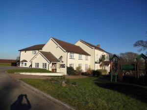 een groot wit huis met een speeltuin ervoor bij Brewers Lodge in Blackwood