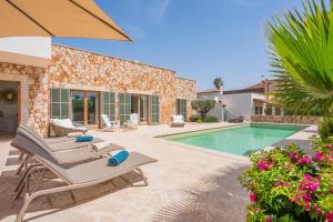 a villa with a swimming pool and patio furniture at Casa Puro in Cala Llombards