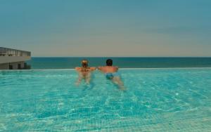 a man and woman standing in the water in a swimming pool at RH Bayren Hotel & Spa 4* Sup in Gandía