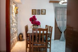 a dining room table with a vase of flowers on it at Areopolis Central in Areopoli +10 photos