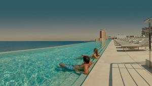 a boy and a girl laying in a swimming pool at RH Bayren Hotel & Spa 4* Sup in Gandía