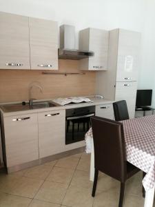 a kitchen with a sink and a table with chairs at Casa Vacanze Il Quadrifoglio in Noto