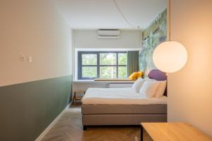 a small bedroom with a bed and a window at Badhuis Hotel in Utrecht