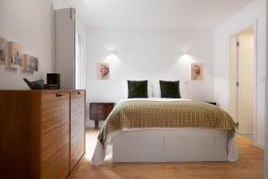 ein weißes Schlafzimmer mit einem Bett und einem Holzschrank in der Unterkunft Oporto Classic Terrace in Porto