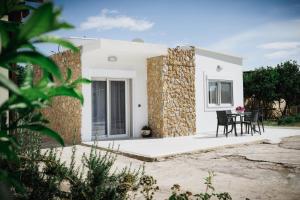 Casa blanca con pared de piedra y mesa en Stella's Holiday House en Tigaki