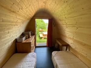 een kleine kamer met 2 bedden en een raam bij Camping Tante Bob & de Rakkertjes in Schoonoord